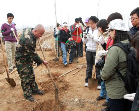 当地林业工人现场演示植树方法